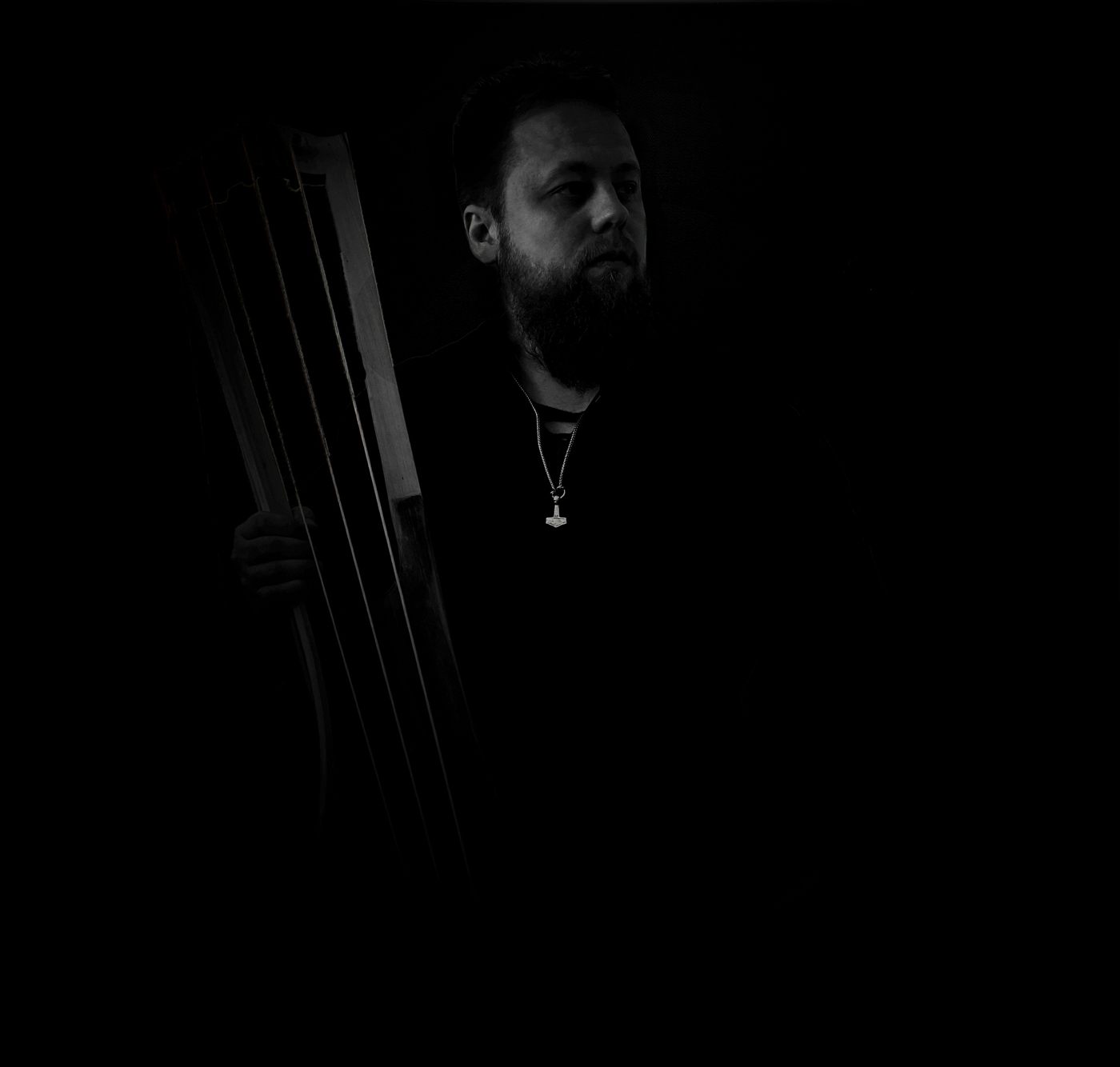 Danheim holding a jouhikko in near darkness
